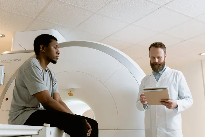 man in scanner at hospital with doctor