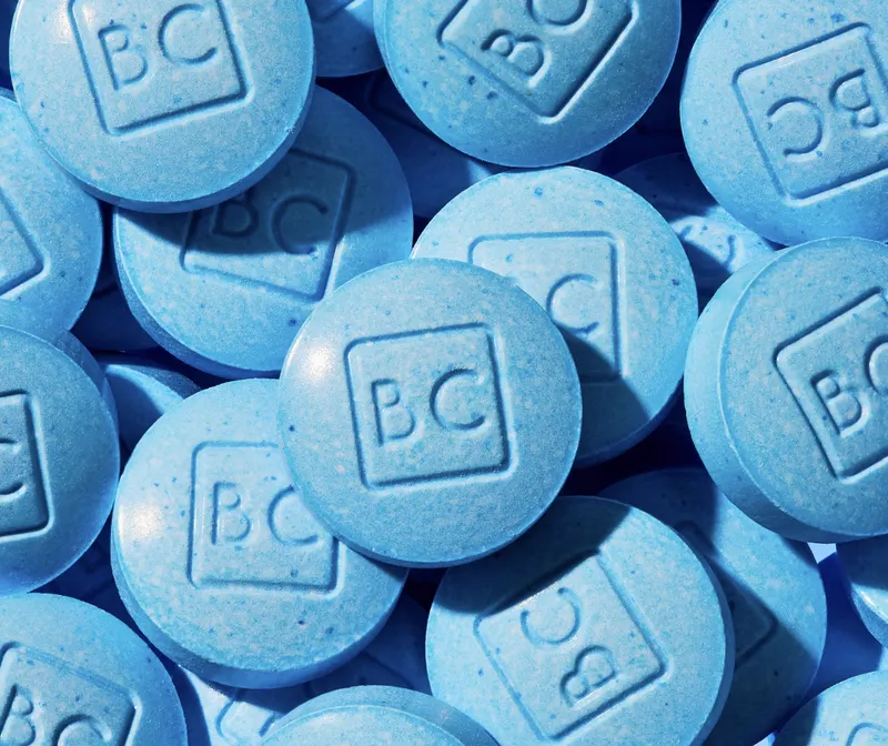 Close-up of a pile of blue BlueChew tablets with 'BC' imprint