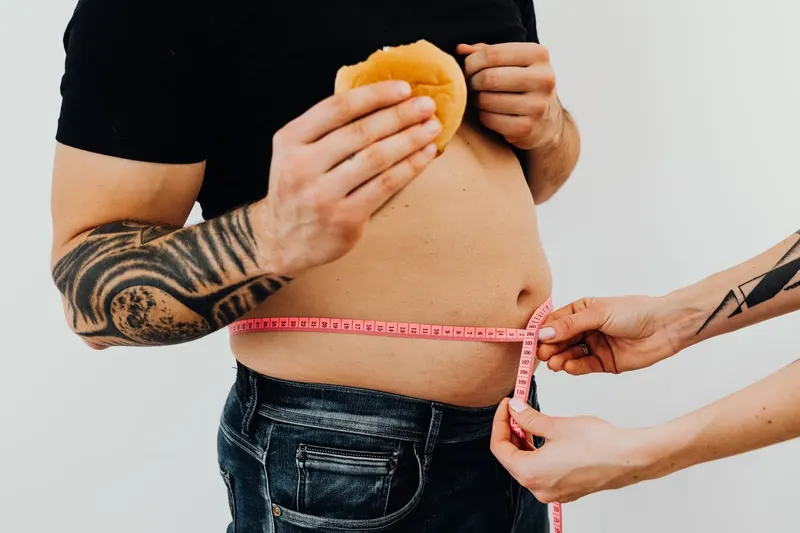 man with abdominal fat being measured