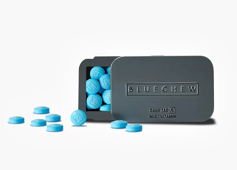 Open black BlueChew Daily case tipped over with scattered blue chewable tablets