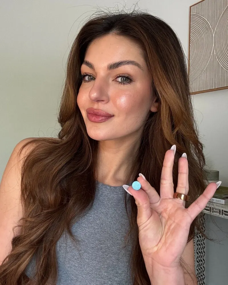 bluechew woman holding blue sublingual tablet