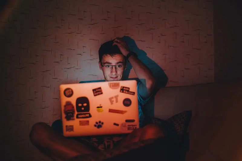 Man sitting alone looking at phone, appearing distracted or preoccupied