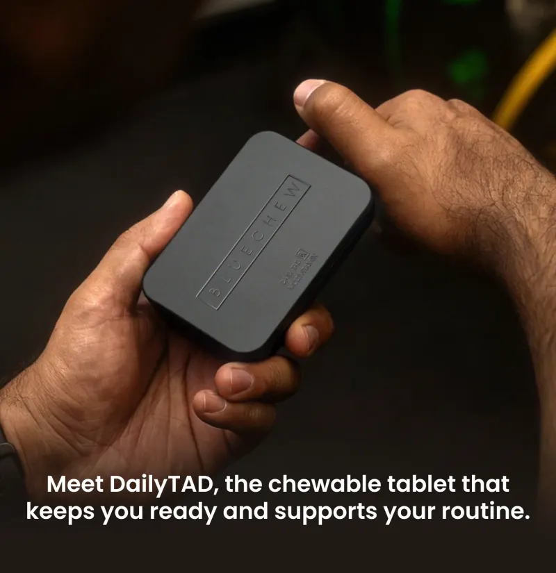 mans hands holding dailyTAD tin in dark room