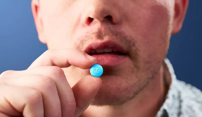 man holding BC tablet to mouth