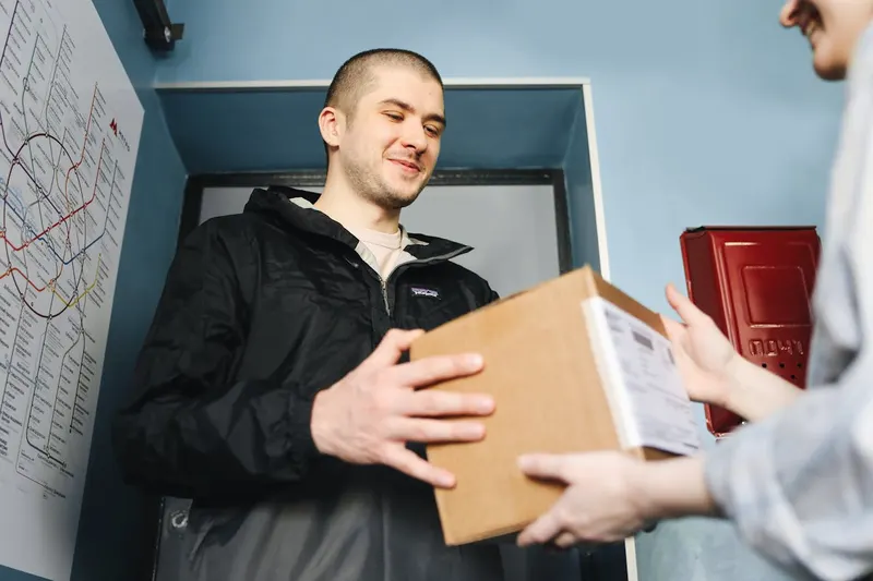 Man receiving a cardboard delivery package at his front door