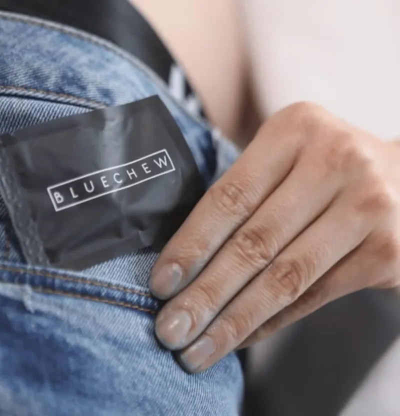 BlueChew sachet tucked discreetly into a jeans pocket