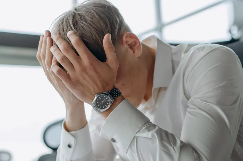 man stressed with head in his hands