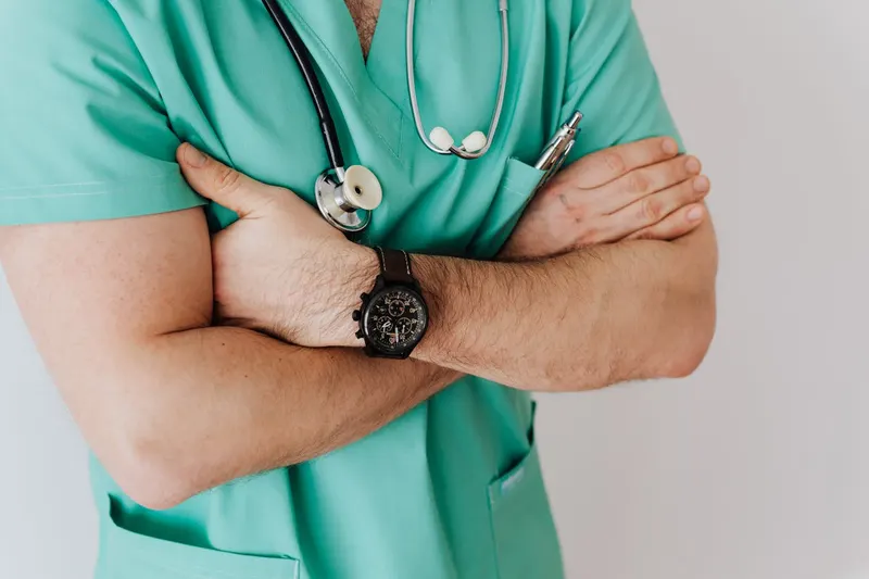 telehealth male doctor in surgical green scrubs