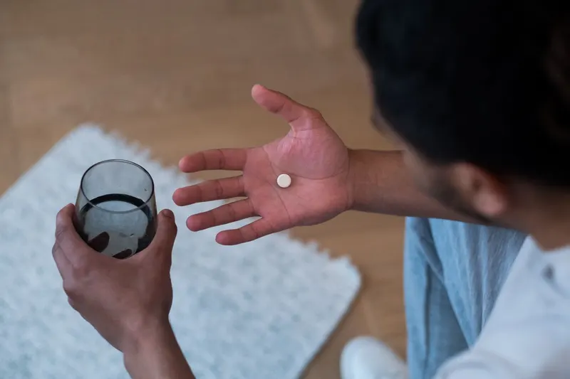 man holding pill in hand