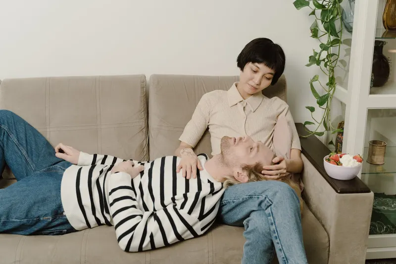 couple on couch with mans head in her lap