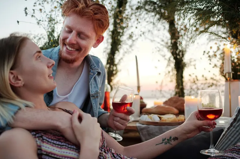 Man and woman smiling and talking closely outdoors at sunset
