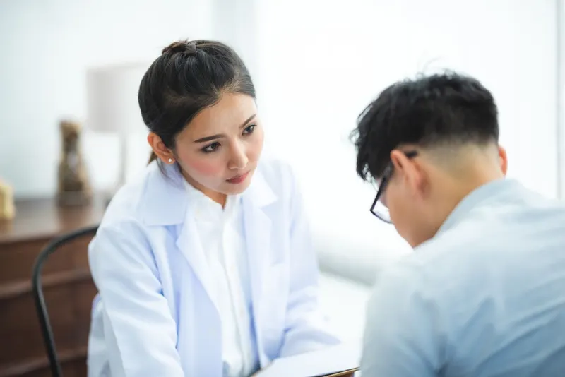 Person sitting in a doctor's office, preparing to discuss a sensitive health topic