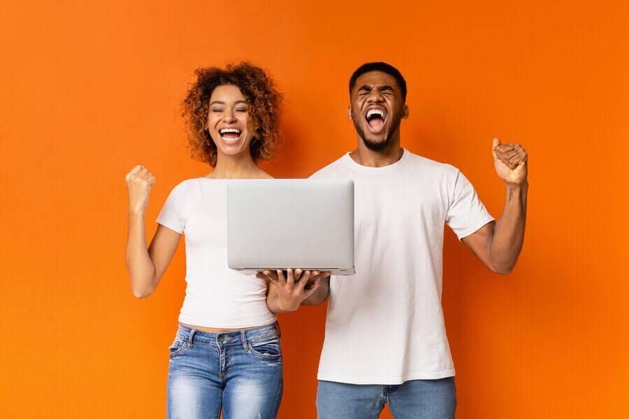 two people celebrating with laptop on their hand
