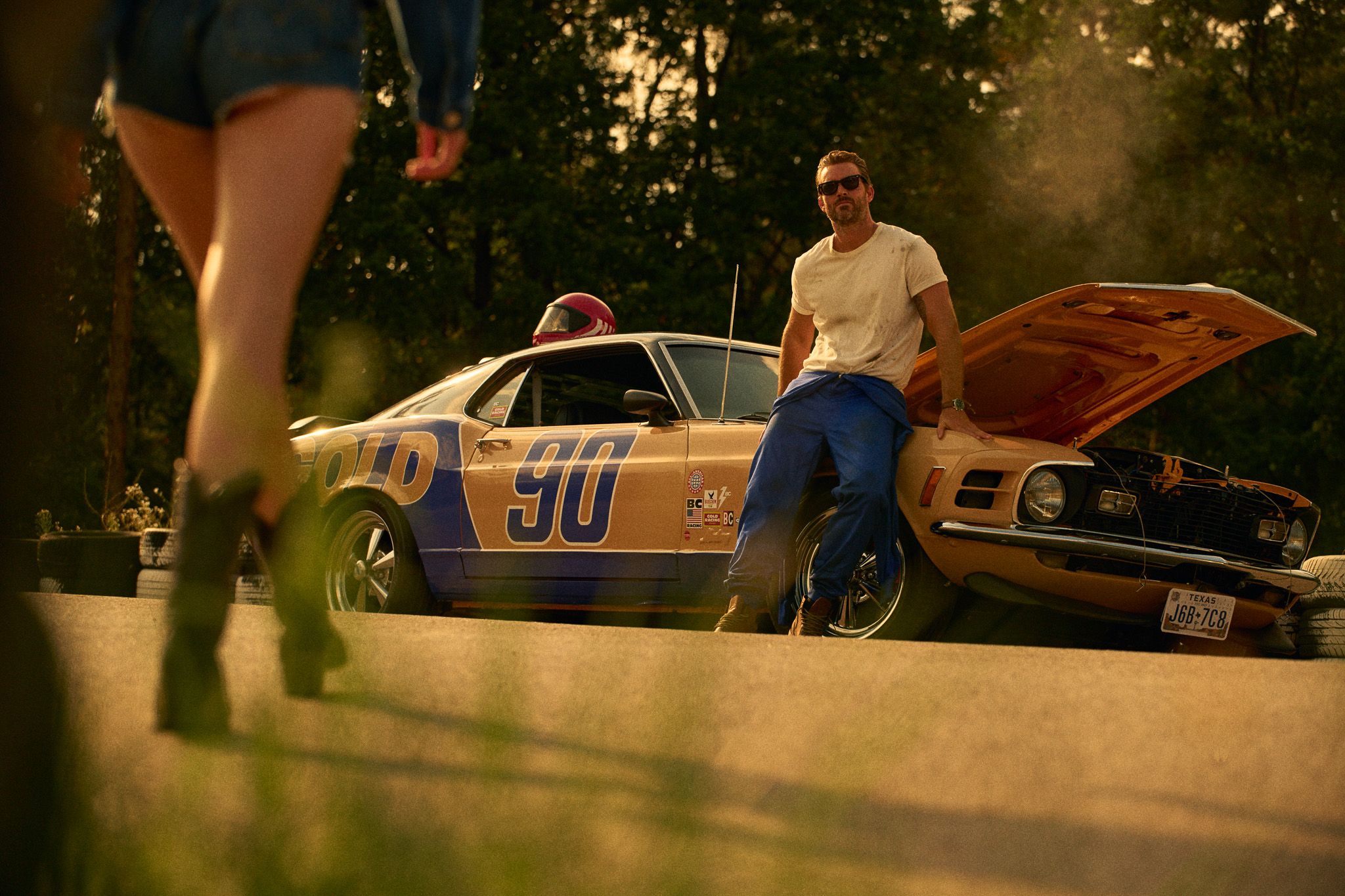 woman with american flag walking to bluechew race car