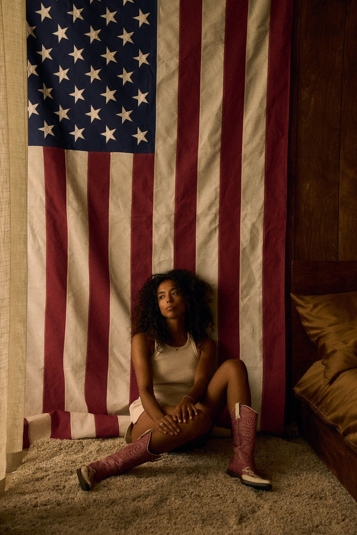 young woman in front of american flag on the floor cowboy boots
