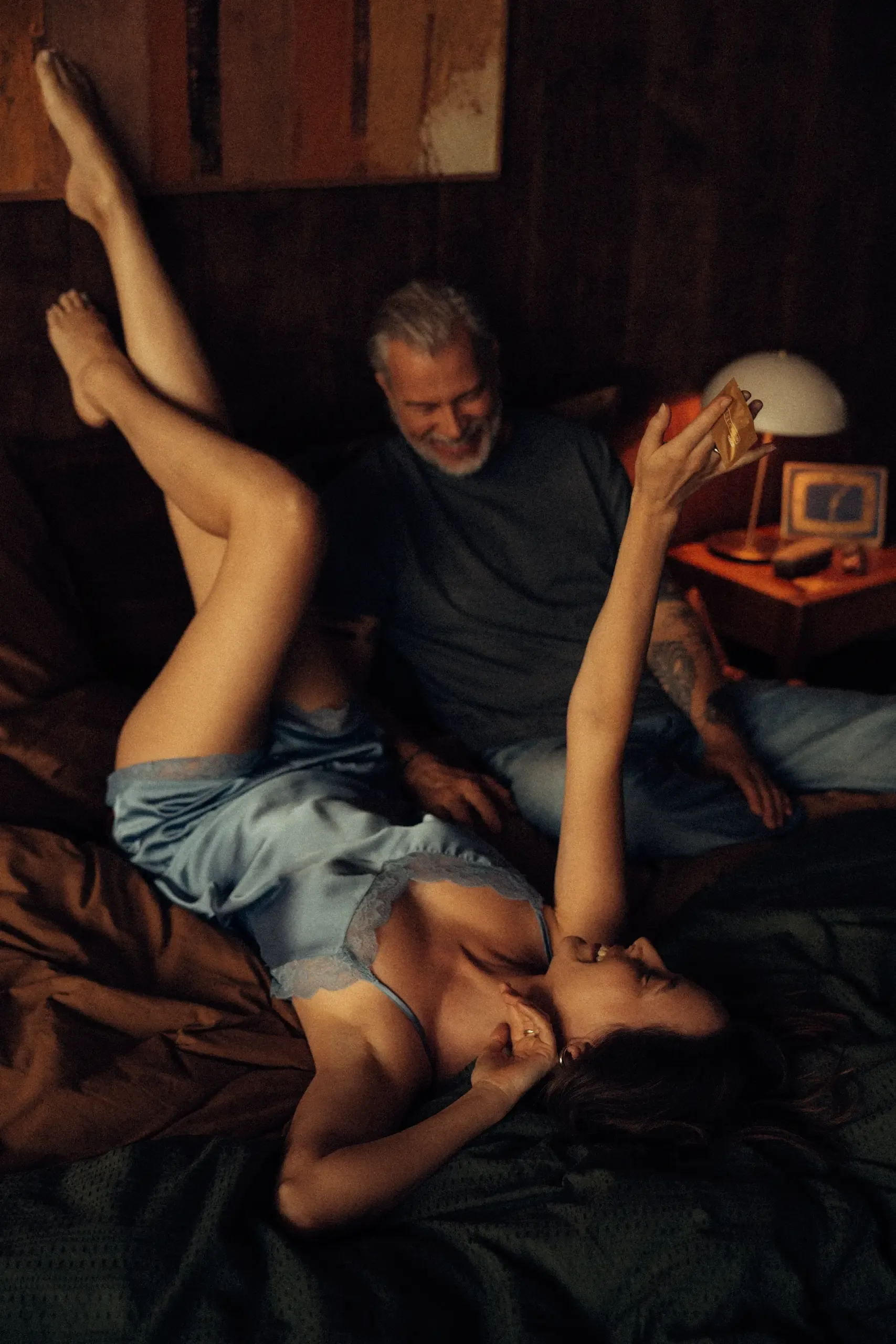 woman on edge of bed in a cowboy hat and night gown