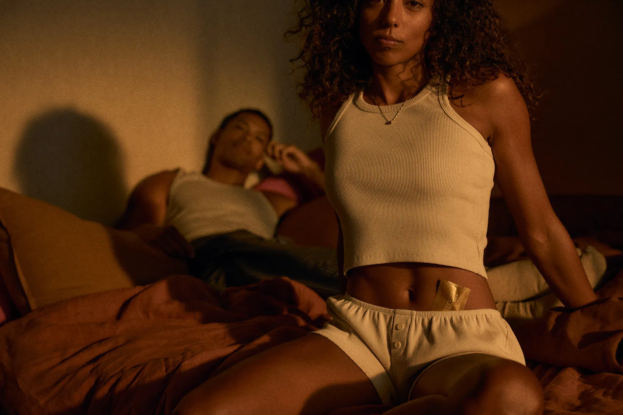 woman on bed with a man bluechew gold in pants