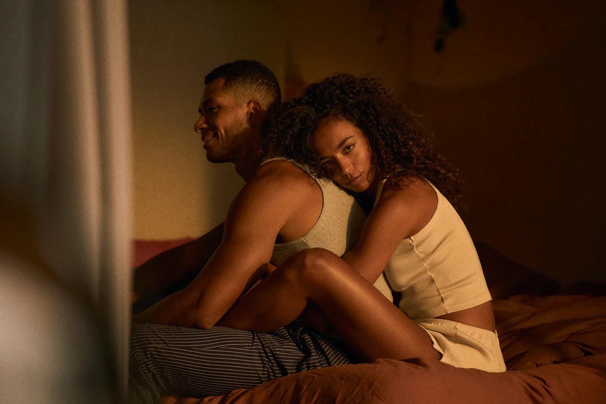 couple in bedroom on bed hugging with bluechew
